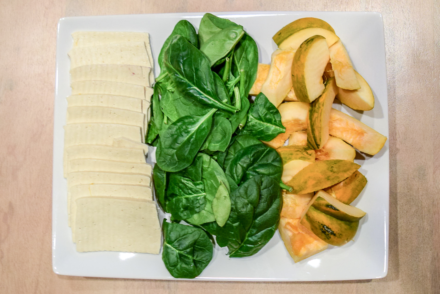 Tofu, spinach, and acorn squash on plate for Instant Pot Hot Pot