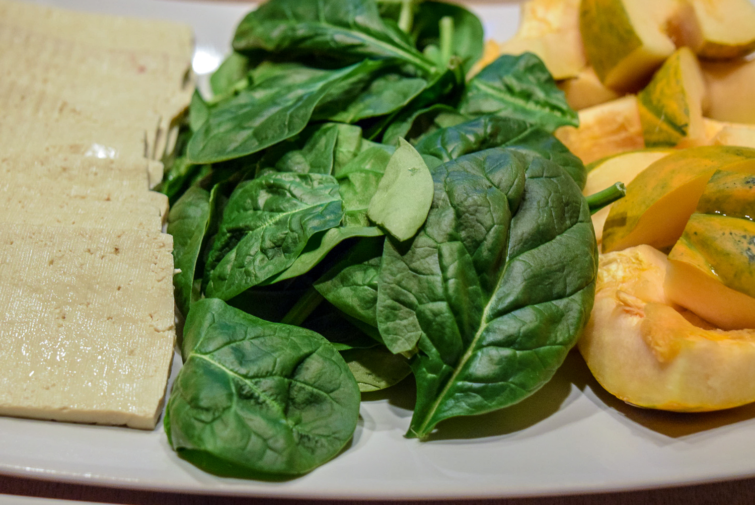 Tofu, spinach, and acorn squash on plate for Instant Pot Hot Pot up close