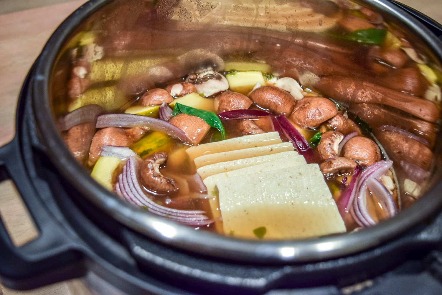 Instant Pot Hot Pot with Vegetables, Tofu, and Ramen Noodles boiling in Instant Pot