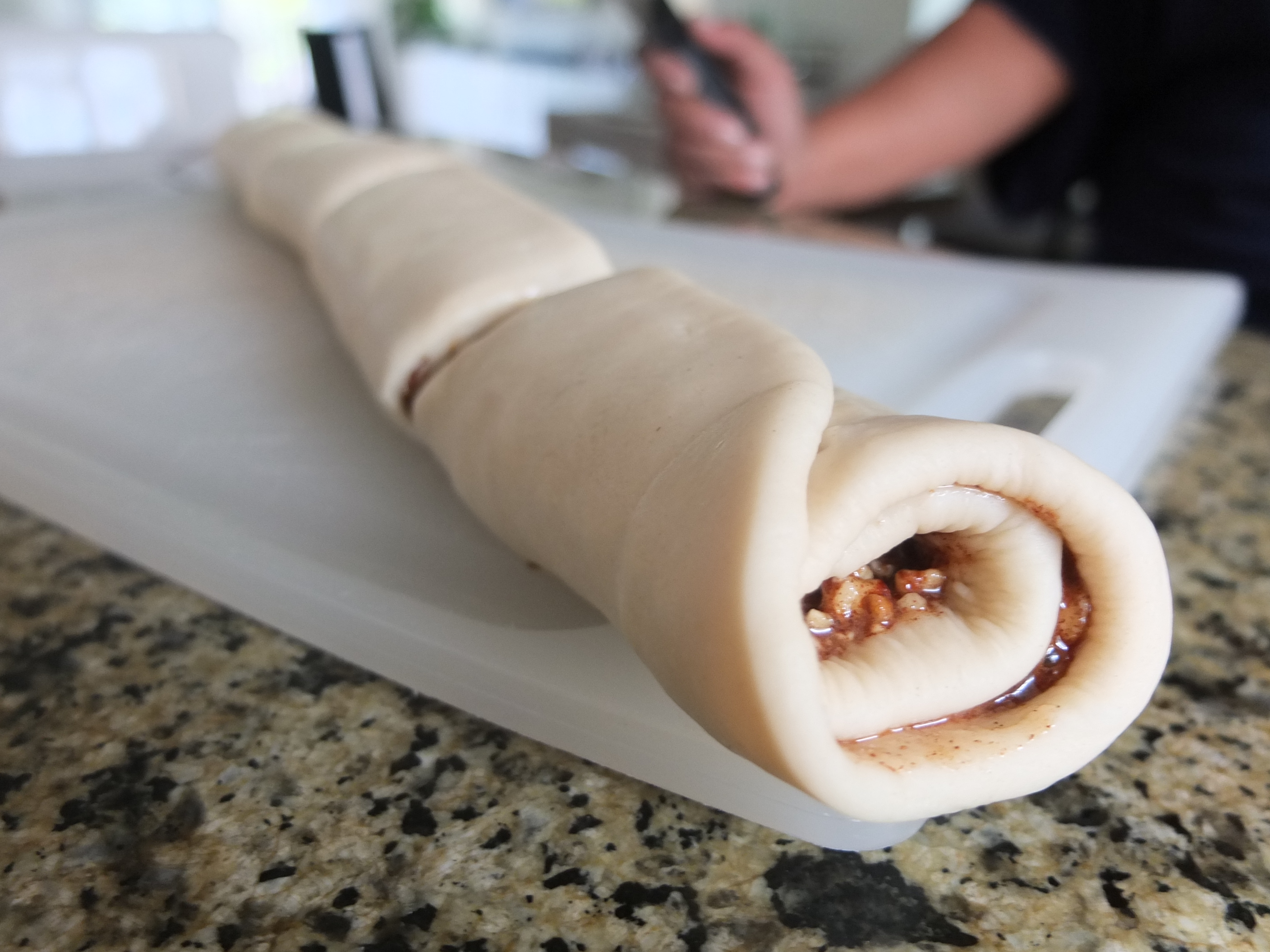 Rolled up dough with fillings for Sesame and Pecan Schnecken Rolls with Orange Glaze