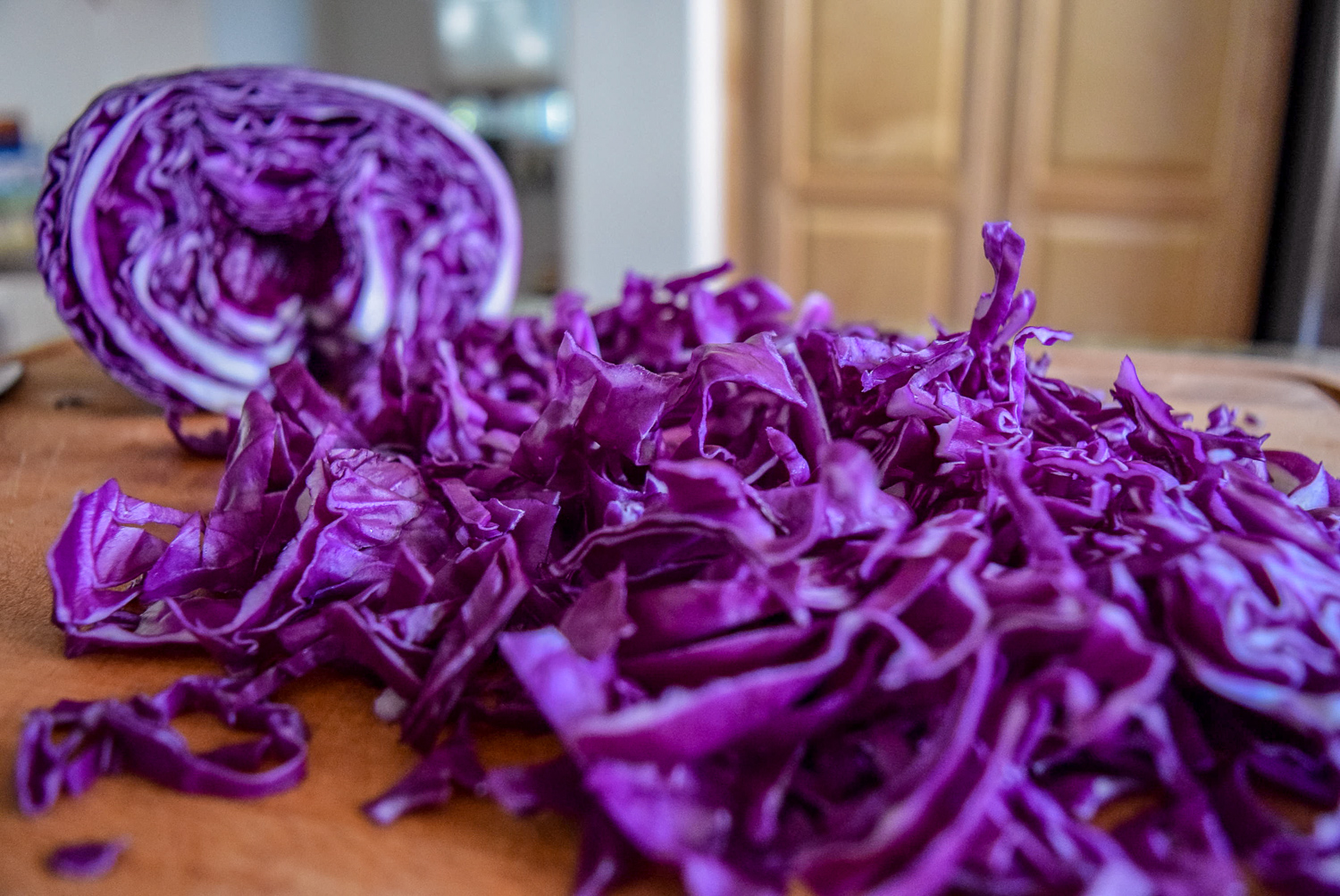 Thinly sliced red cabbage for Sunshine Spicy Mustard Tahini Cruciferous Slaw