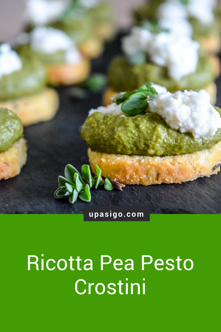 Marjoram Pea Pesto Crostini with Fresh Ricotta on slate cheeseboard from front angle