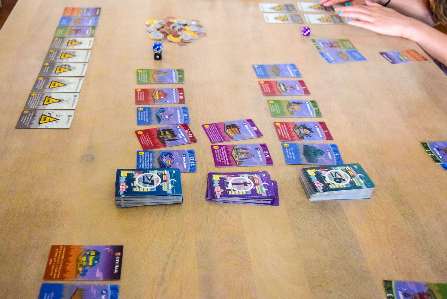 Central card stacks for playing Machi Koro: Bright Lights, Big City from side