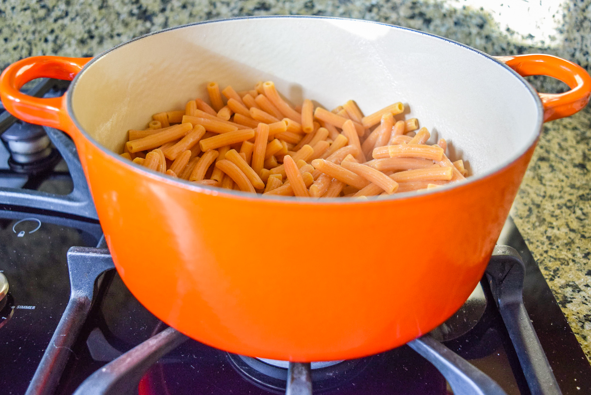 Cooked and strained Trader Giotto’s Organic Red Lentil Sedanini Pasta in Flame Le Creuset Dutch Oven