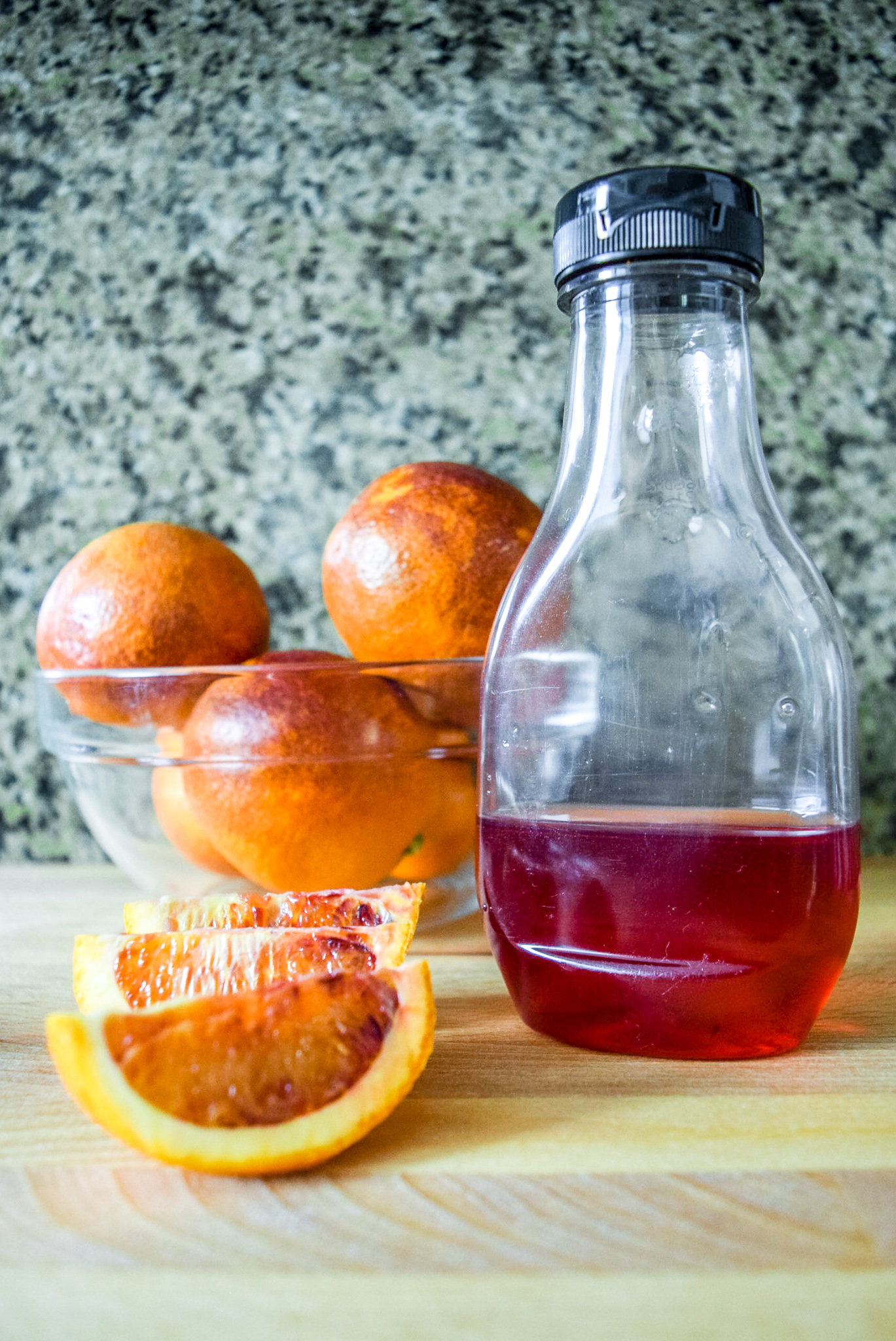 Finished blood orange syrup with sliced blood oranges from top
