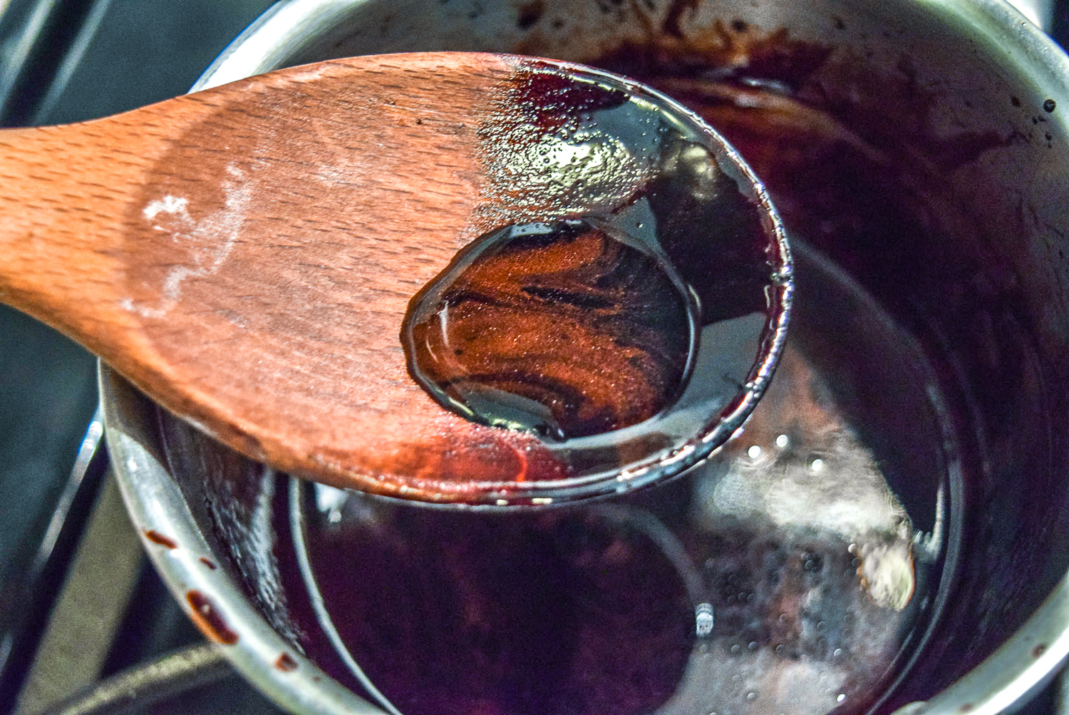Finished balsamic reduction in spoon for caprese bruschetta