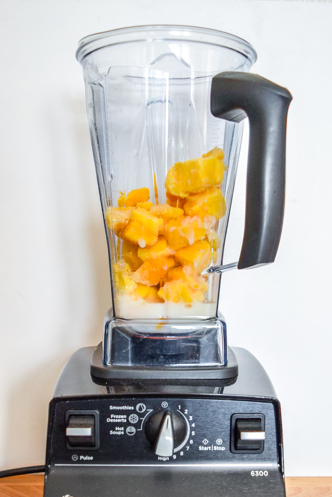 Ingredients for Two-Ingredient Almond Mango Ice Cream in the Vitamix blender from front