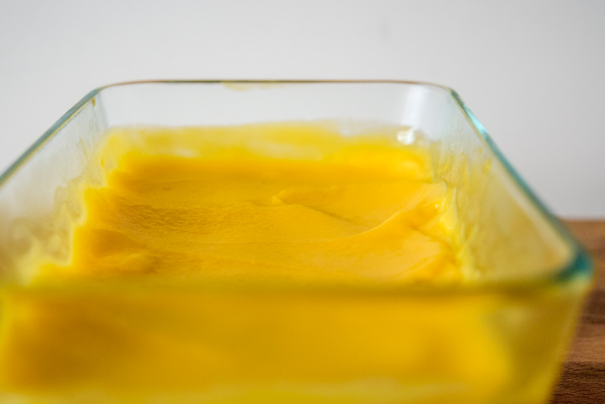 Two-Ingredient Almond Mango Ice Cream from front up close in pyrex glass container