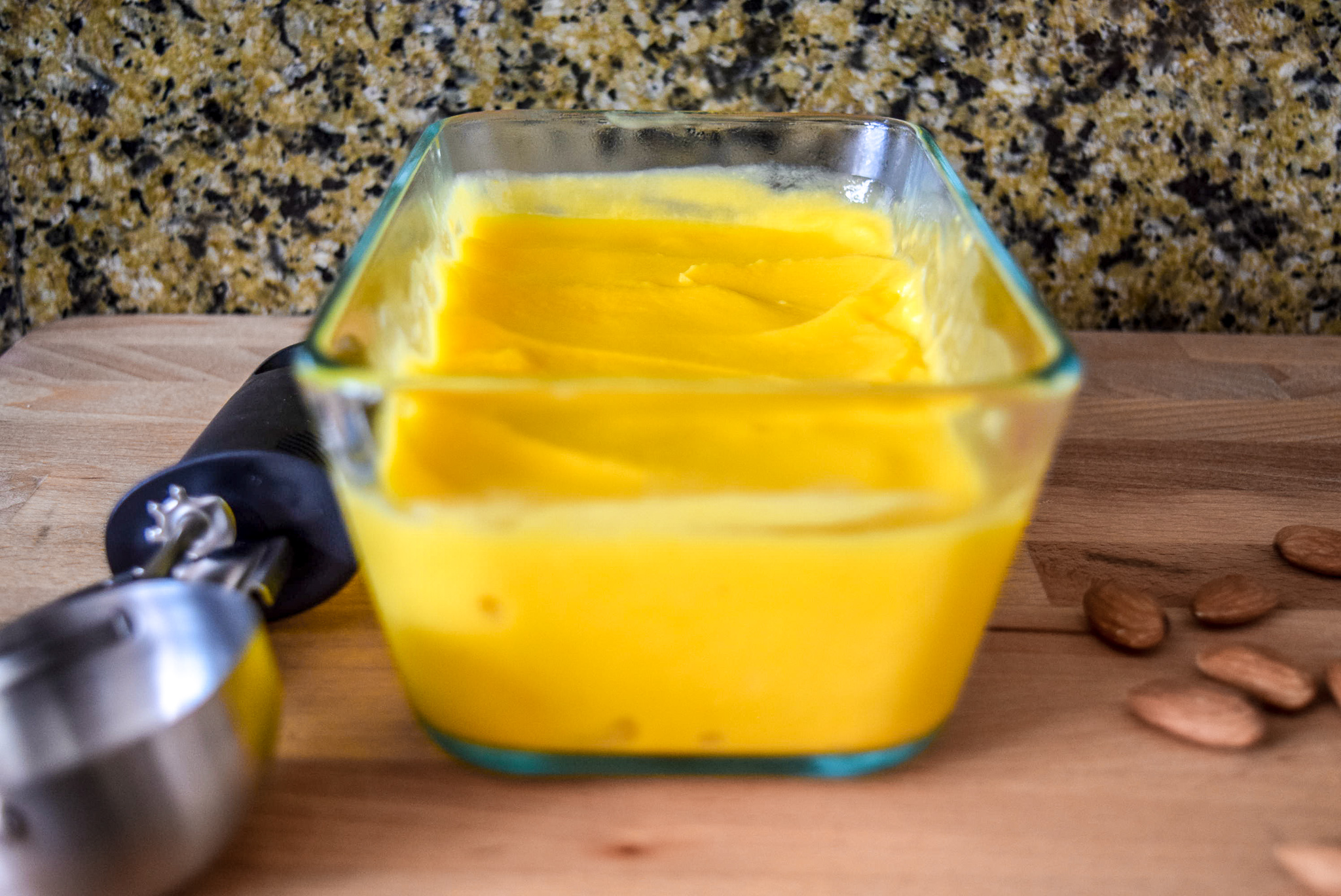 Finished vegan Two-Ingredient Almond Mango Ice Cream with ice cream scoop