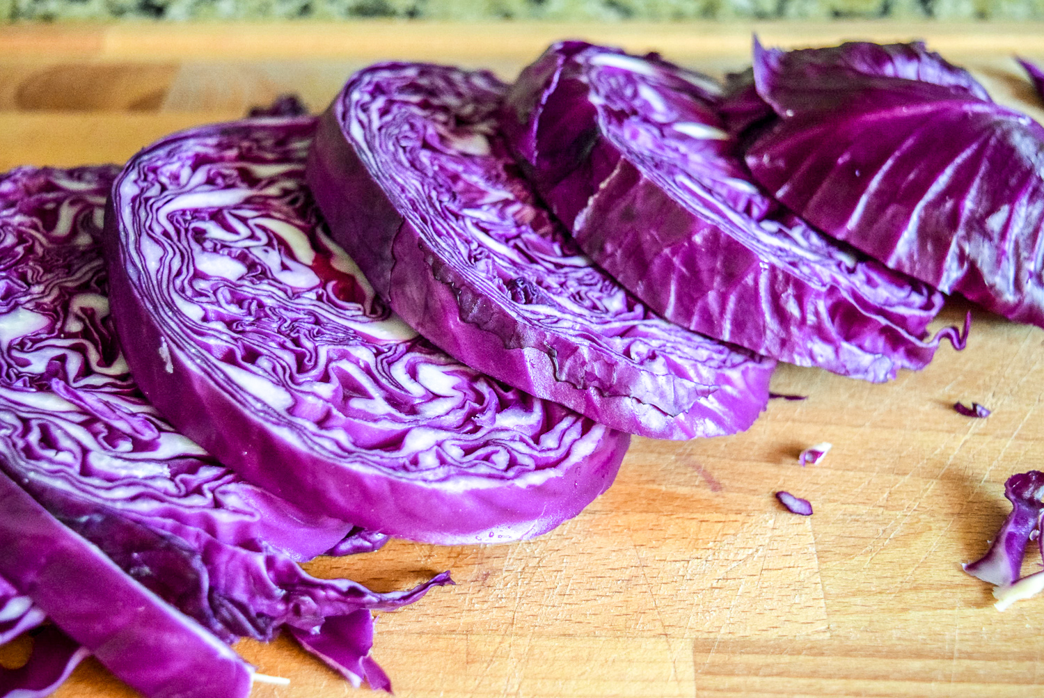 Sliced red cabbage steaks on wooden cuttingboard from top