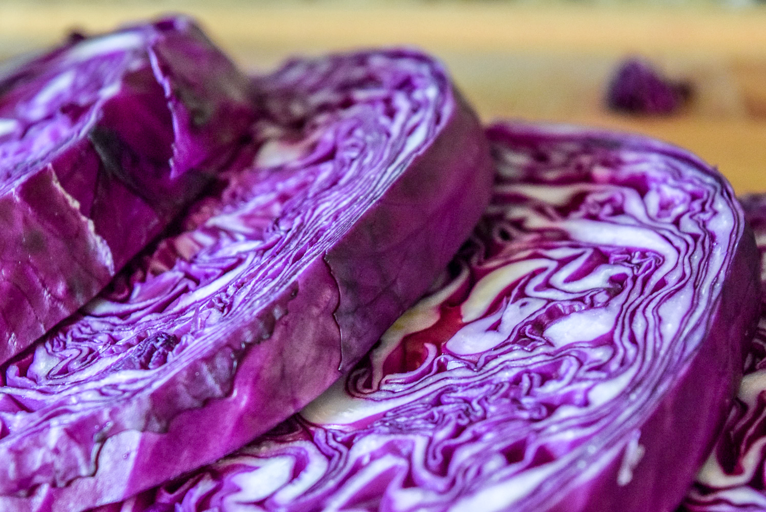 Sliced red cabbage steaks on wooden cuttingboard from side up close